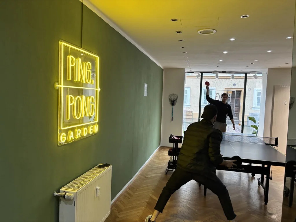 Neon-Schriftzug „Ping Pong Garden“ im Indoor-Tischtennisraum in Salzburg