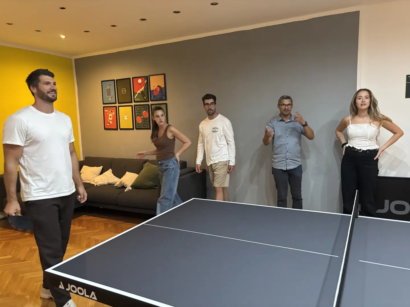 Gruppe von Freunden rund um die Tischtennisplatte im Ping Pong Garden Salzburg