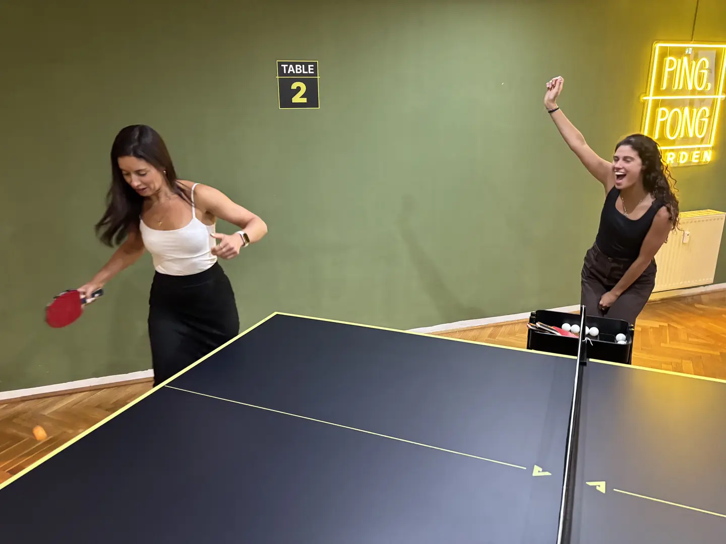 Zwei Spielerinnen im Match an Tisch 2, eine jubelt nach dem gewonnenen Punkt